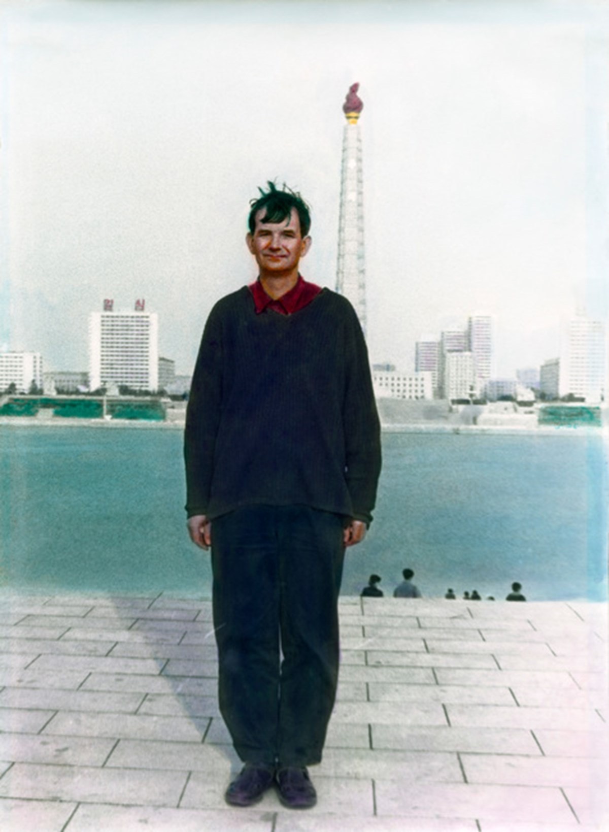 マーティン・パー『平壌、北朝鮮』(1997)。平壌の写真館で主体思想塔の背景幕を置いて撮った自画像 (ⓒMartin Parr/Magnum Photos)