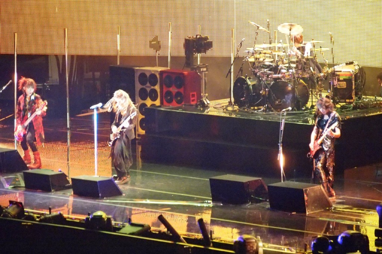 為替が立てた自国のヘッドライナー · 25周年のヘッドライナーに上がるL'Arc~en~Ciel。円安で海外のヘッドライナーの招聘が高くなると、自国の大型バンドを前に立てて費用と興行を一緒につかんだ。ⓒWikimedia Commons