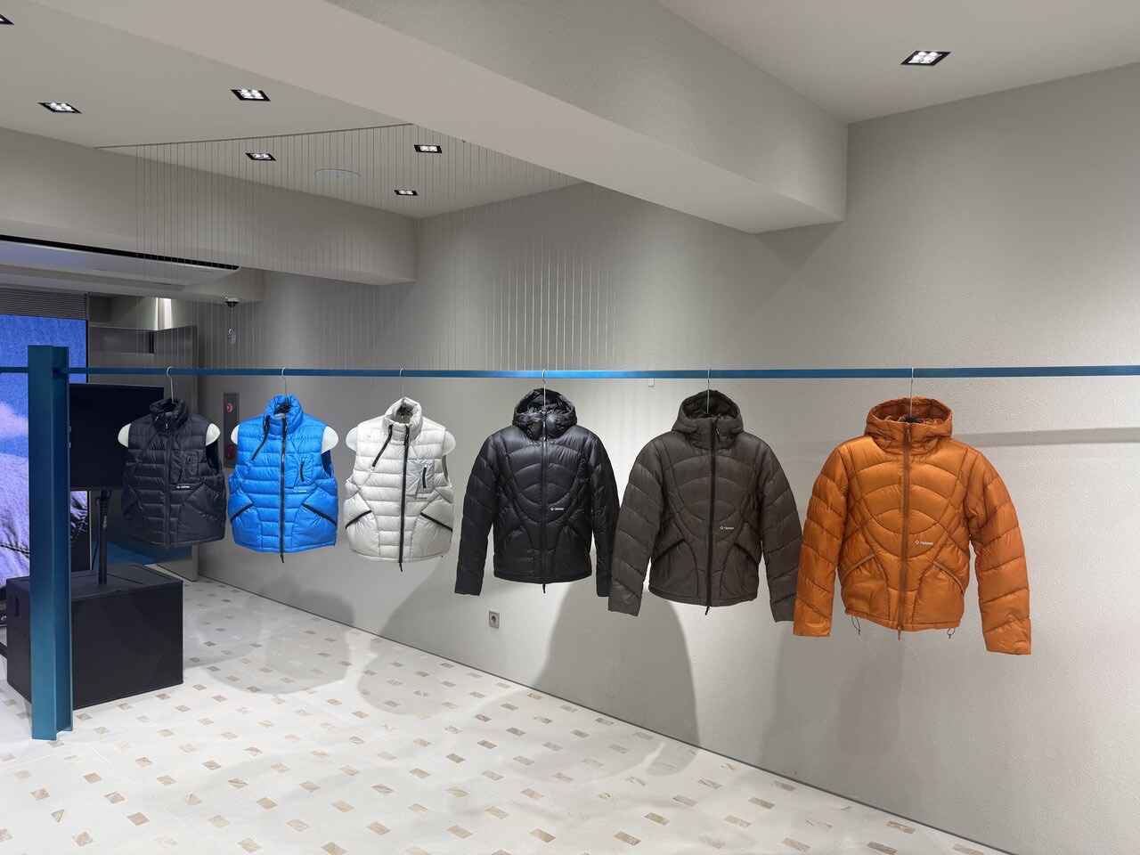 One piece at a time · Down vests and jackets hang one per color, spaced apart. ⓒBloter