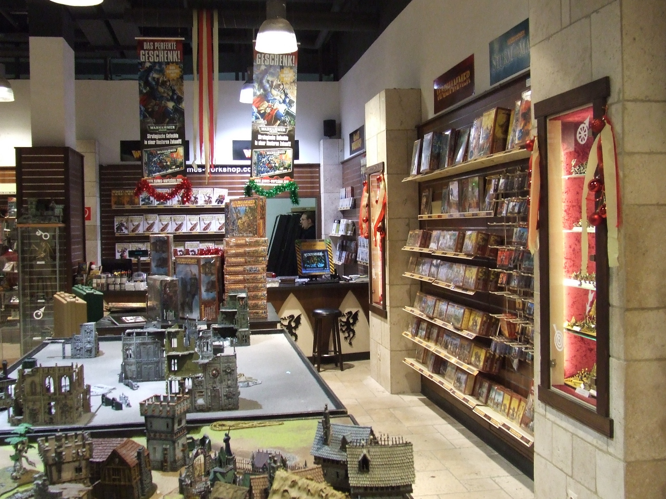 매장 한가운데 탁자 · 오스트리아 빈의 Games Workshop 직영 매장. 벽은 상자 진열, 가운데는 지형을 깐 게임 탁자다. ⓒChristo · CC BY-SA 4.0
