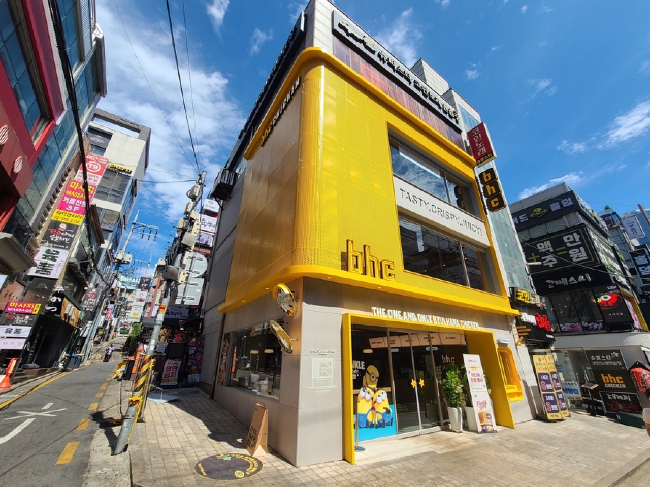 강남역 이면 · 코너에서 본 외관. 왼쪽으로 경사진 골목이 이어지고 간판이 빼곡하다. ⓒ더구루