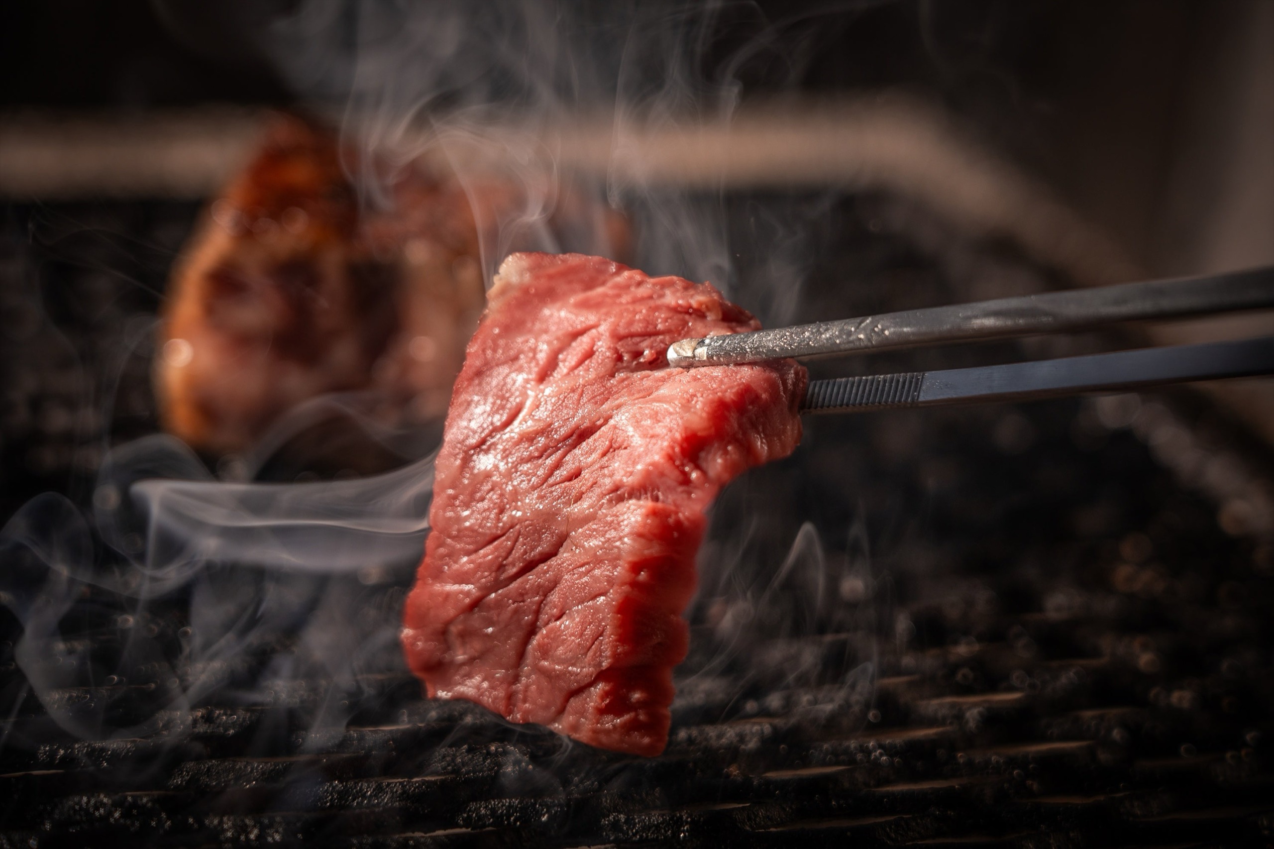 卓上で · 焼き上げる最後の工程を客の前へ移した。奥にはすでに焼けた塊。©ダイヤモンドダイニング