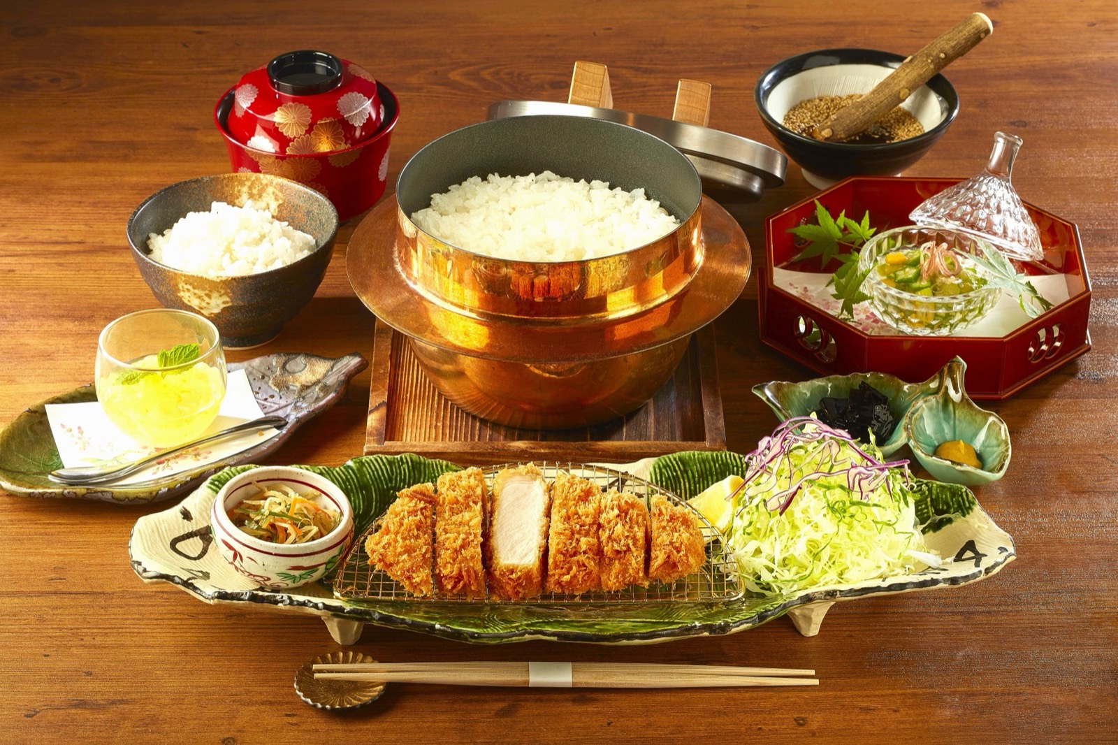 One person's tray · The rice arrives in the pot, not in a bowl. Twenty minutes on the fire, started after the order. ⓒ株式会社グリーンハウスフーズ