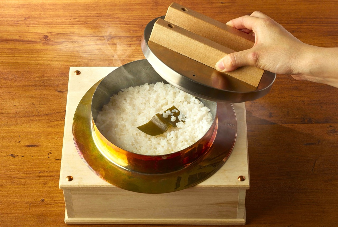 The lid comes off · It is opened in front of the guest. For someone who has waited twenty minutes this is not cooking, it is a signal. ⓒ株式会社グリーンハウスフーズ