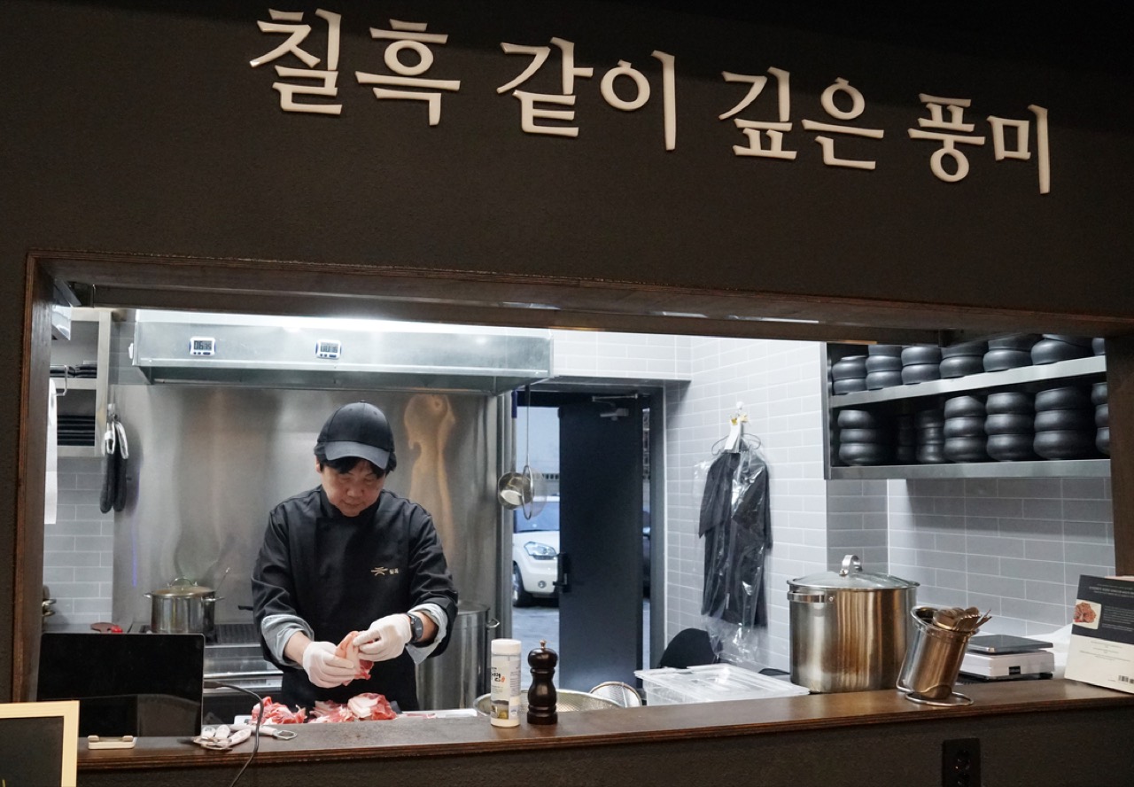 창구 · 벽에 붙인 글씨 아래가 그대로 주방이다. 손질하는 손이 홀에서 보인다. ⓒ경향신문