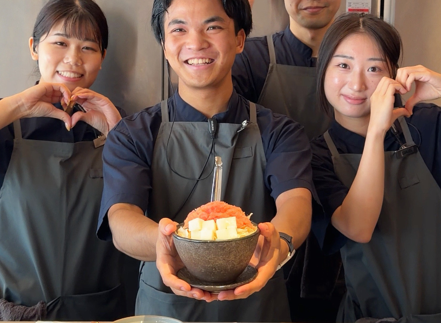 明太子もちもんじゃ一杯 · 韓国1号店の開業告知とともに公開された写真。スタッフが明太子もちもんじゃの具材の器を掲げている。ⓒ패스트페이퍼