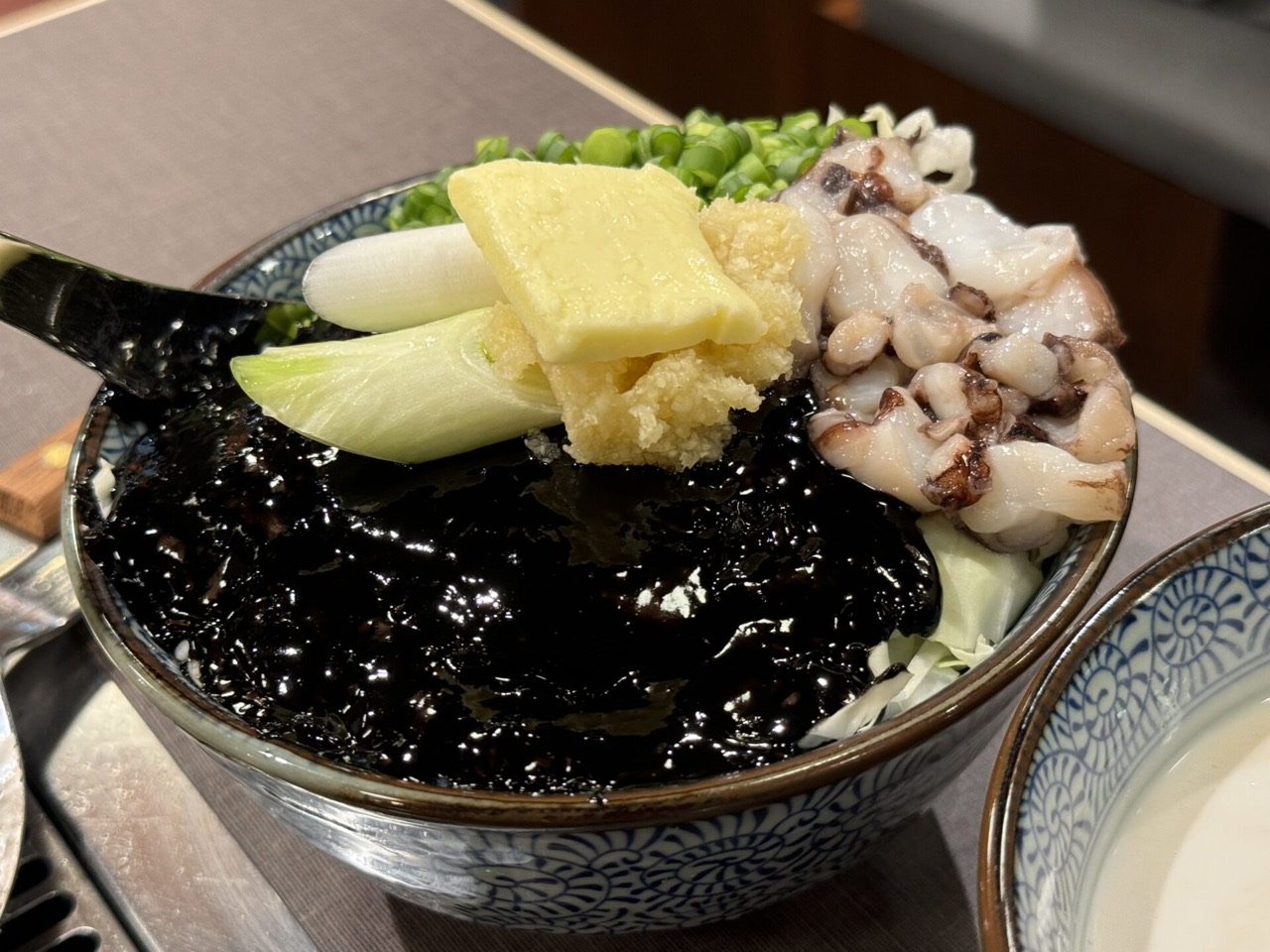 イカ墨もんじゃ · 黒い具材の上にバターとイカを載せて出す。吉祥寺店では1,958円だった。ⓒ吉グル