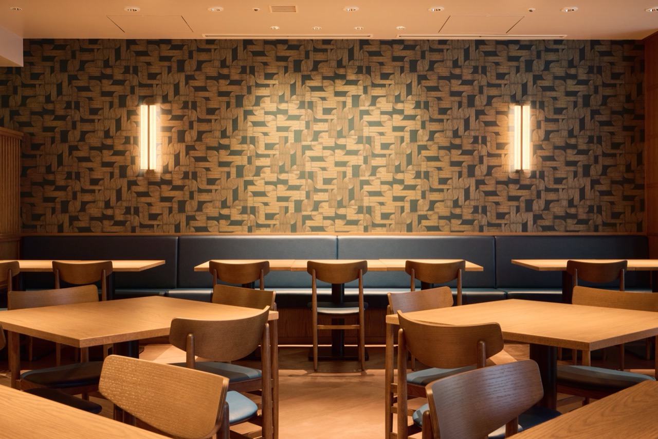 타일 벽과 벤치 좌석 · 무늬 타일 벽을 따라 남색 벤치가 붙고, 세로로 긴 벽등이 빛을 위아래로만 흘린다. ⓒ田中コーポレーション