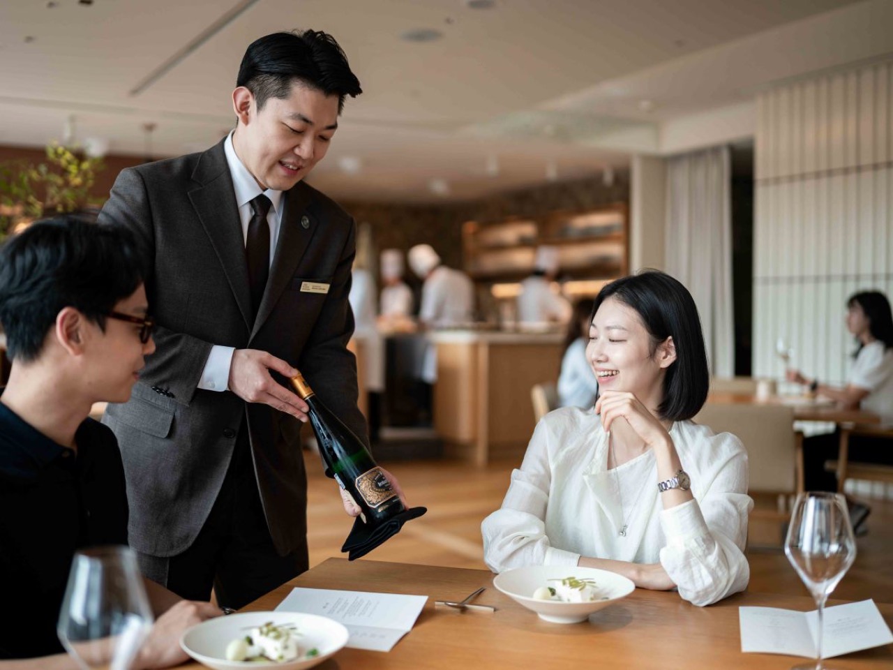 테이블에서 와인을 따르는 소믈리에 · 소믈리에 팀 하나가 세 식당을 오간다. ⓒ한화푸드테크