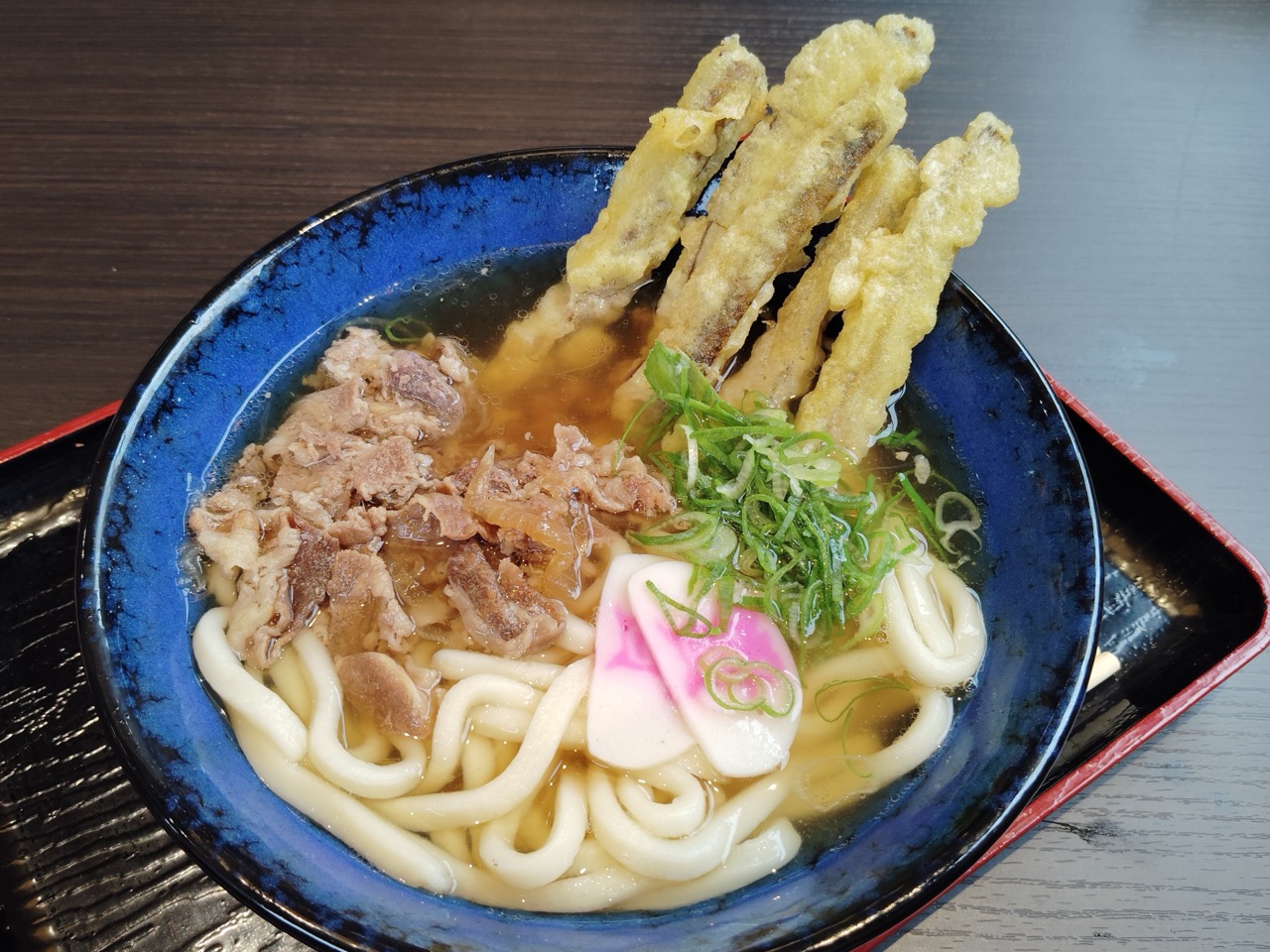 肉ごぼ天うどん · 煮た牛肉とごぼ天を一緒にのせる看板メニュー。ⓒAsturio Cantabrio · CC BY-SA 4.0