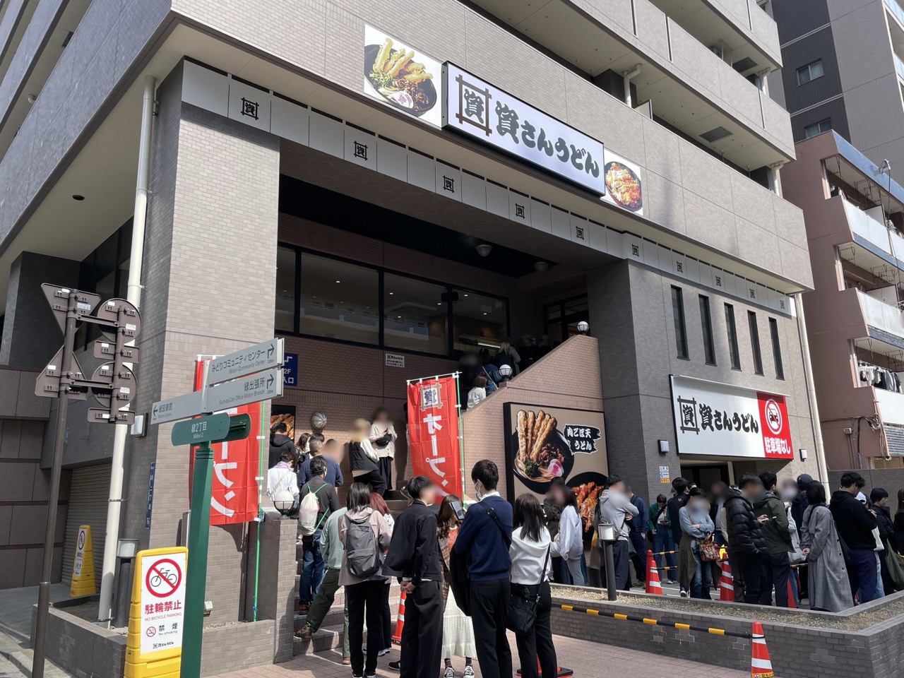東京・両国店の行列 · オフィスビル1階の店の前の歩道に沿って客が並んだ。ⓒTotti · CC BY-SA 4.0