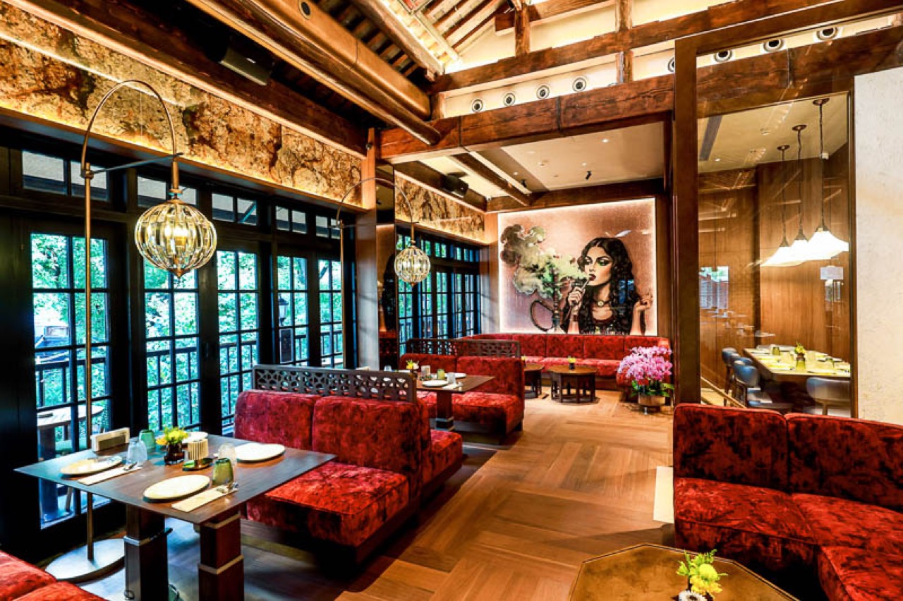 Red sofas and the mural · The wooden lattice windows belong to the shikumen; the mural and lamps are new. ⓒNOMFLUENCE