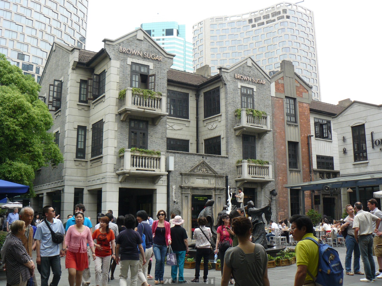 Xintiandi pedestrian zone · A car-free plaza. Towers rise behind the shikumen roofs. ⓒCan Pac Swire · Wikimedia Commons (CC BY-SA 2.0)