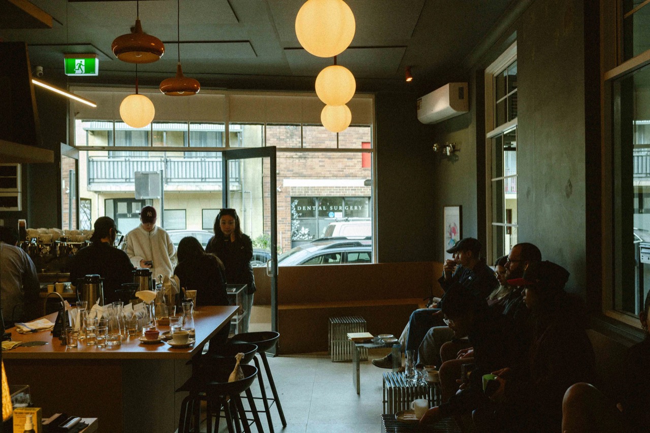 A room longer than it is wide · Bar counter and stools on the left, the built in banquette along the right wall. Beyond the glass is the dental surgery across the road. ©Yusuke Oba · Broadsheet