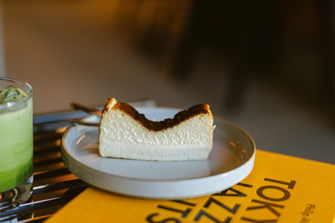 Reference material on the table · Basque cheesecake and matcha resting on a yellow book, Tokyo Jazz Joints. It is a photographic record of Japan's jazz kissa. ©Yusuke Oba · Broadsheet