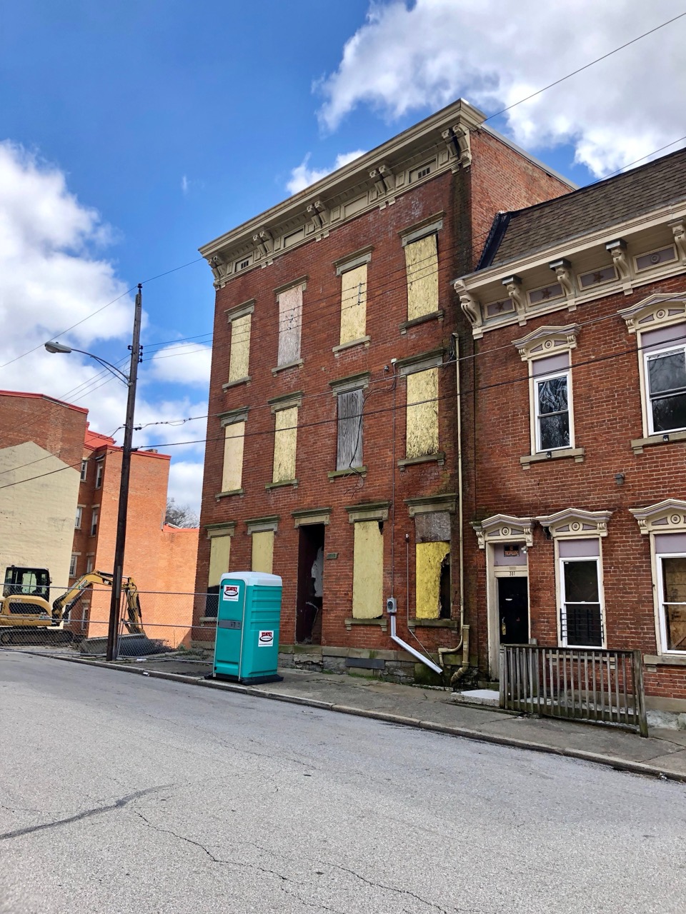 Before and after, wall to wall · Two buildings on Seitz Street, one still boarded up, the other restored, sharing a party wall. ©Warren LeMay · Wikimedia Commons (CC0)
