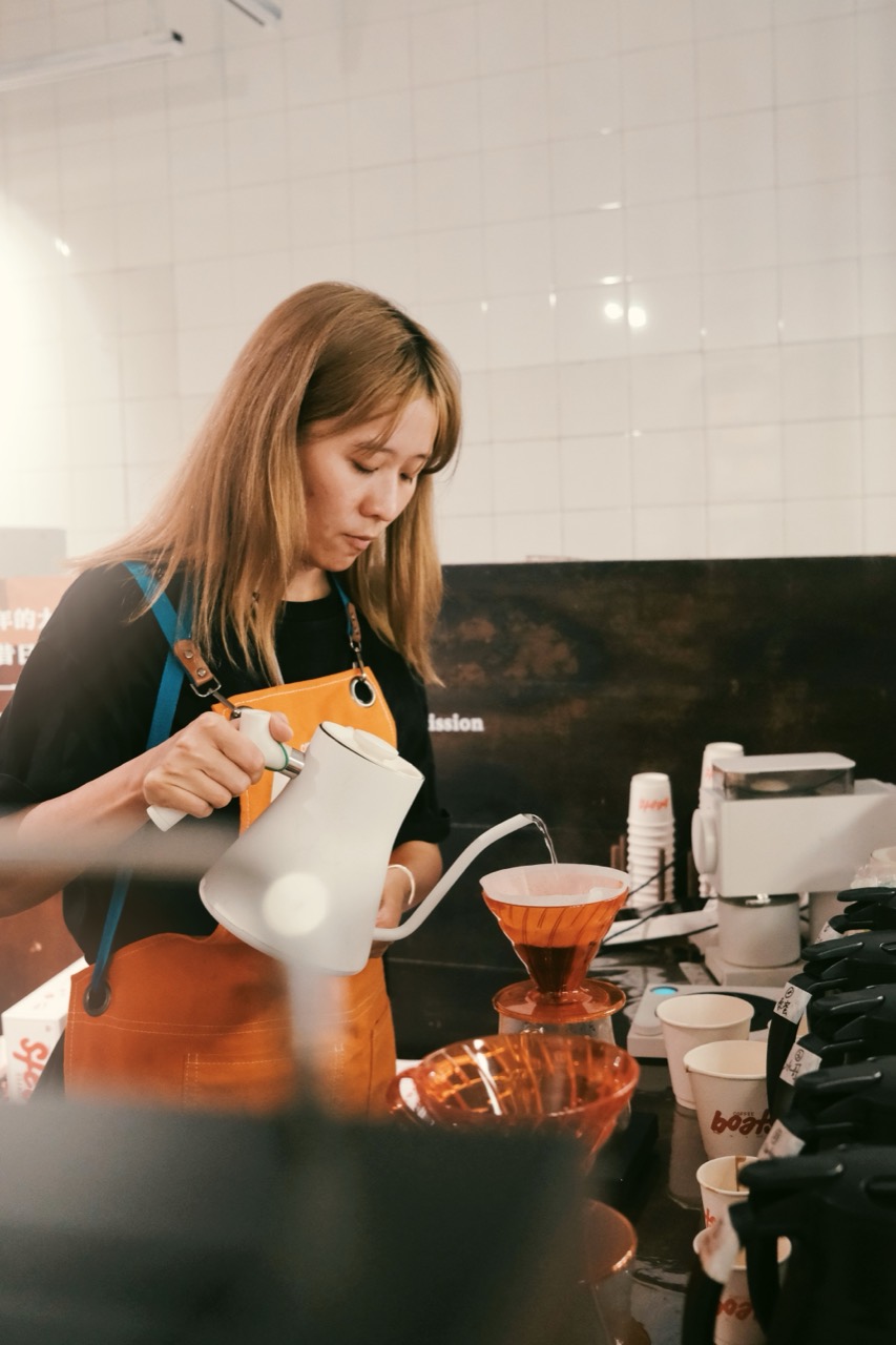 ハンドドリップの一杯 · カウンターの内側でドリッパーに湯を注ぐ。一杯のコーヒーと一緒に豆とドリップバッグも売る。ⓒandthen
