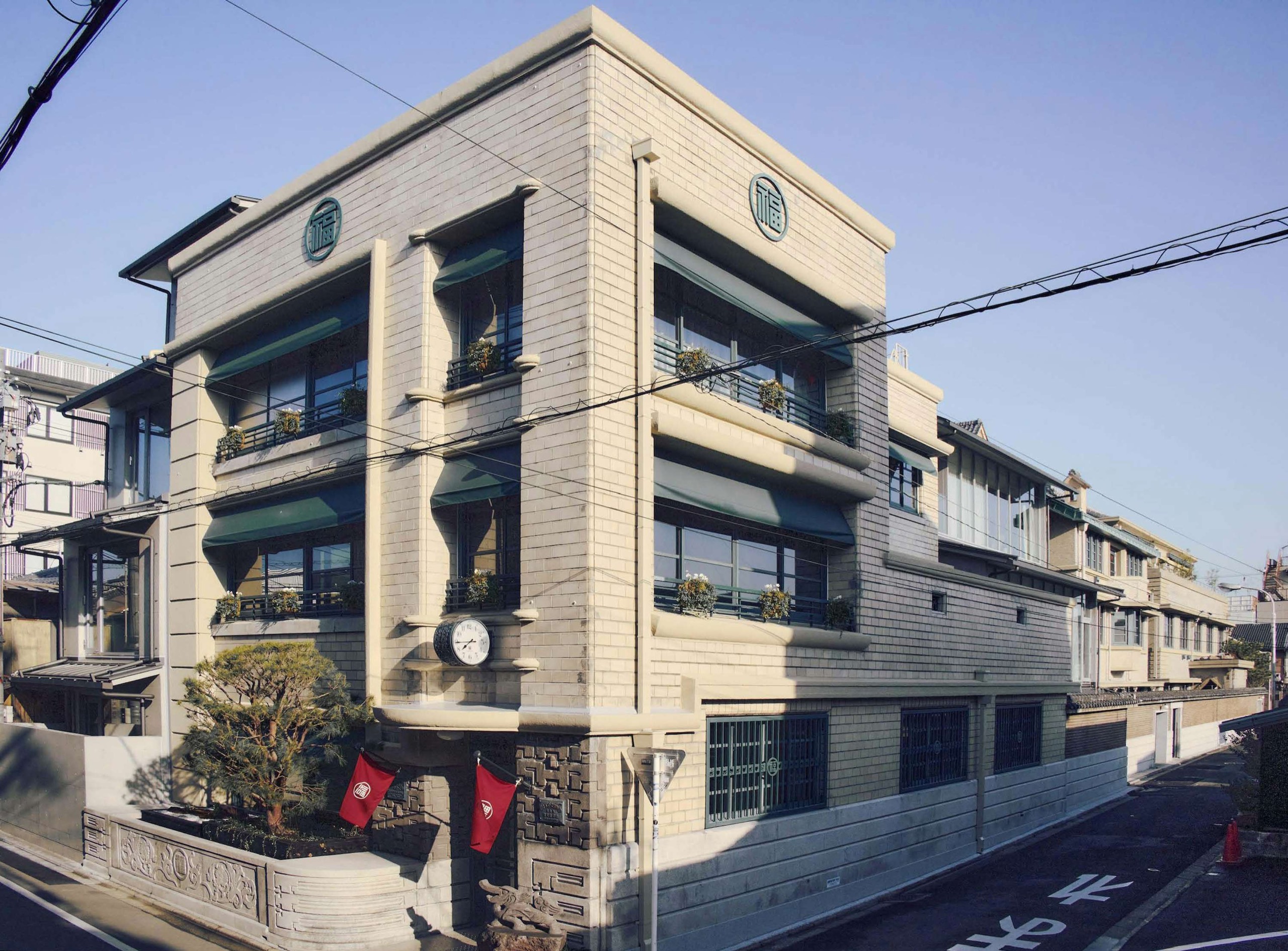 간판 대신 노렌 · 1930년에 지은 옛 사옥을 그대로 남겼다. 벽 위쪽 원형 장식과 문 앞 붉은 노렌에 옛 상호 마루후쿠(丸福)의 사표가 붙어 있다. ⓒ丸福樓 / 美術手帖