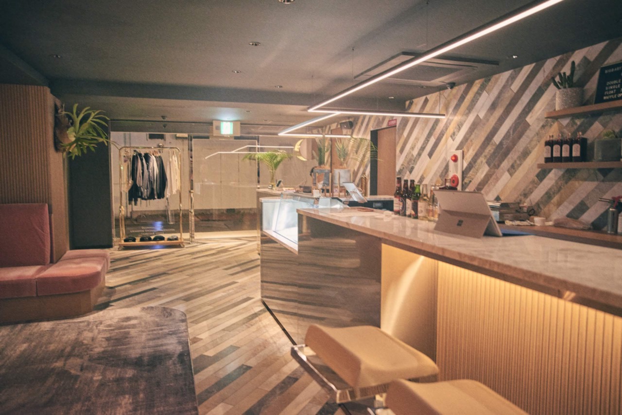 본점 로비 · 같은 회사의 HOTEL SHE, KYOTO. 프런트와 바, 아이스크림 진열장, 옷걸이가 한 자리에 있다. ⓒ株式会社水星