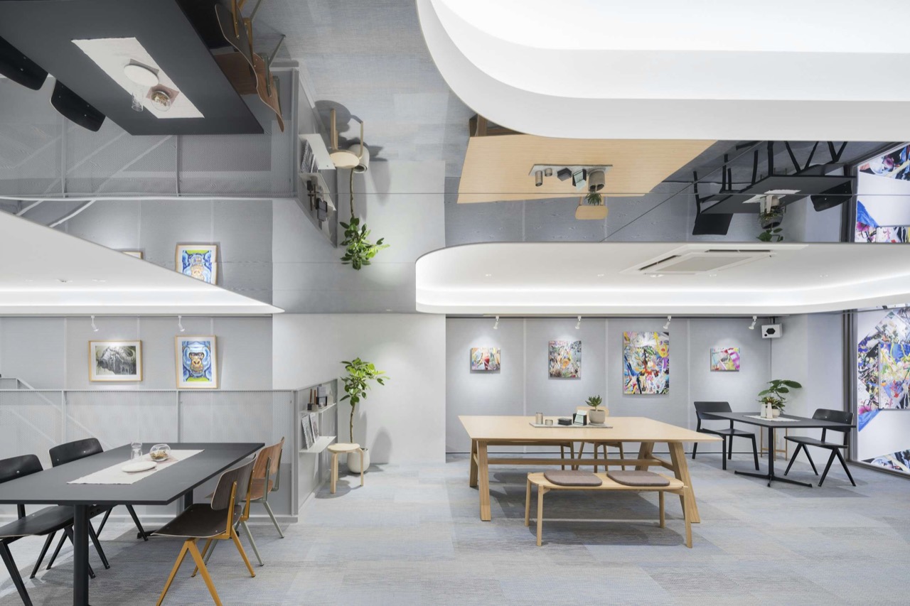 2階のカフェとギャラリー · テーブル脇の壁がそのまま展示壁になる。カフェは12時から18時まで。ⓒ美術手帖