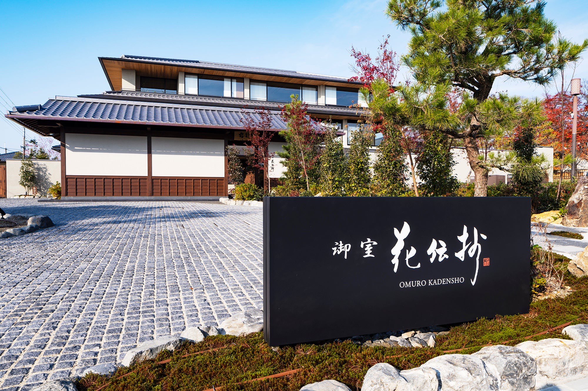 Gravel forecourt and sign · Tiled roofs layered low. The building stands 9.98m tall, just under the site's 10m height limit. ⓒKyoritsu Maintenance