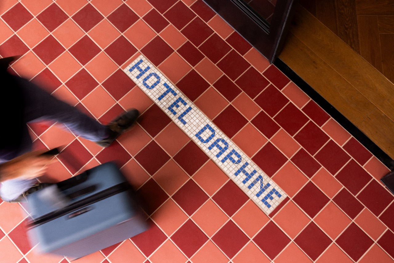 エントランスのタイル · 赤いタイルの床に、モザイクでホテルの名を入れた。ⓒGrant Pifer · Hotel Daphne