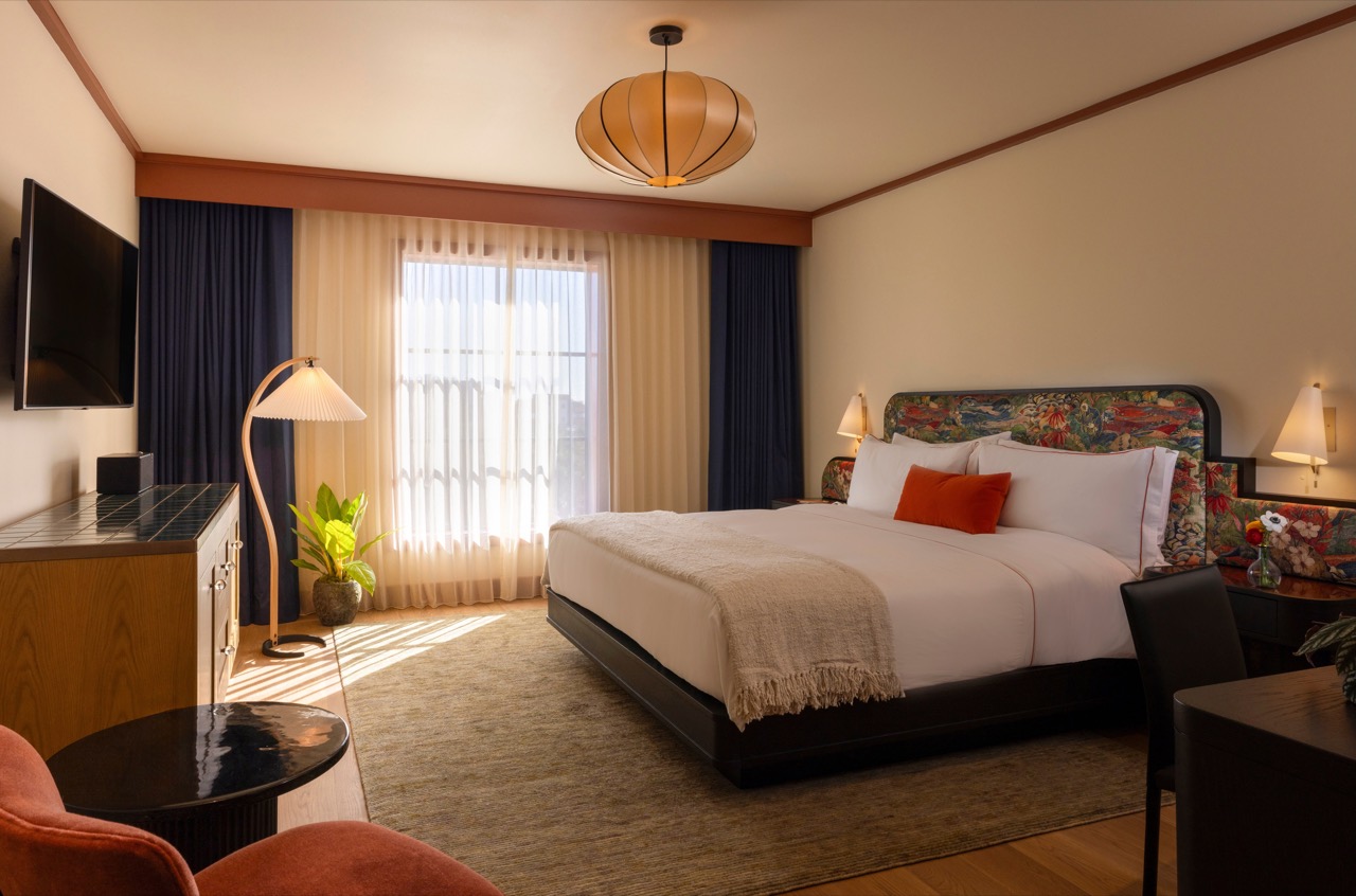 キングベッドの客室 · 花柄の布を張ったヘッドボードと、濃い木のベッドフレーム。ⓒJulie Soefer · Hotel Daphne