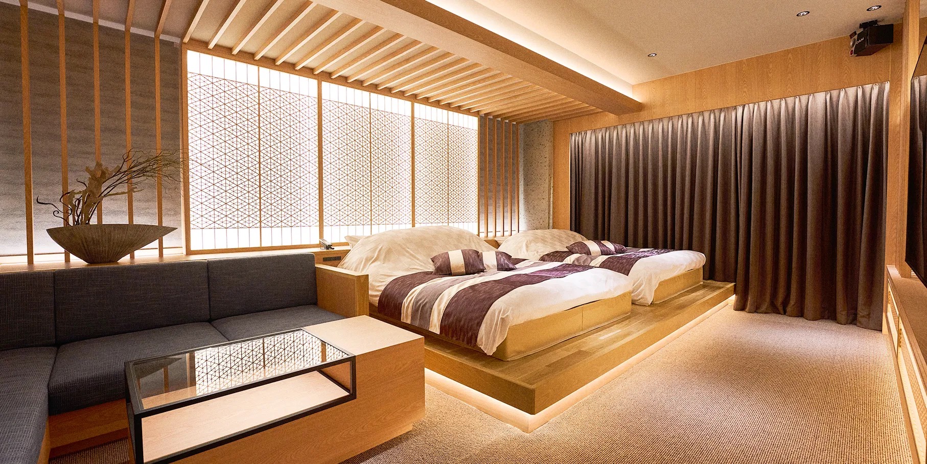 디럭스 퀸 트윈 · 침대 두 개를 단 위에 올리고 앞에 소파 자리를 둔다. ⓒHOTEL MINATO