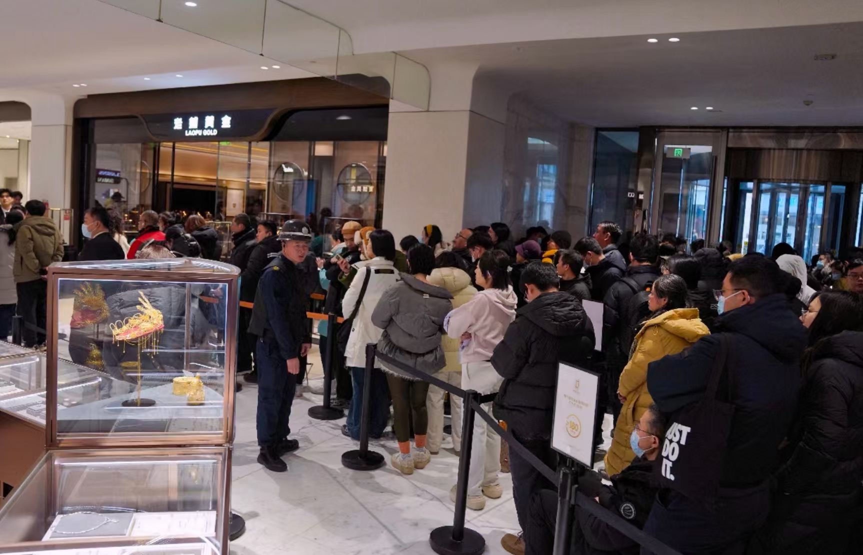줄은 상품의 일부다 · 차단봉으로 동선을 잡고 인원을 끊어 들인다. 이른 대기와 입장 제한이 이 브랜드의 상징이 됐다. 노무라는 2분기에 리베이트·사은품 강화와 진입가를 낮춘 신제품 투입이 있었다고 분석한다. ⓒ新京报