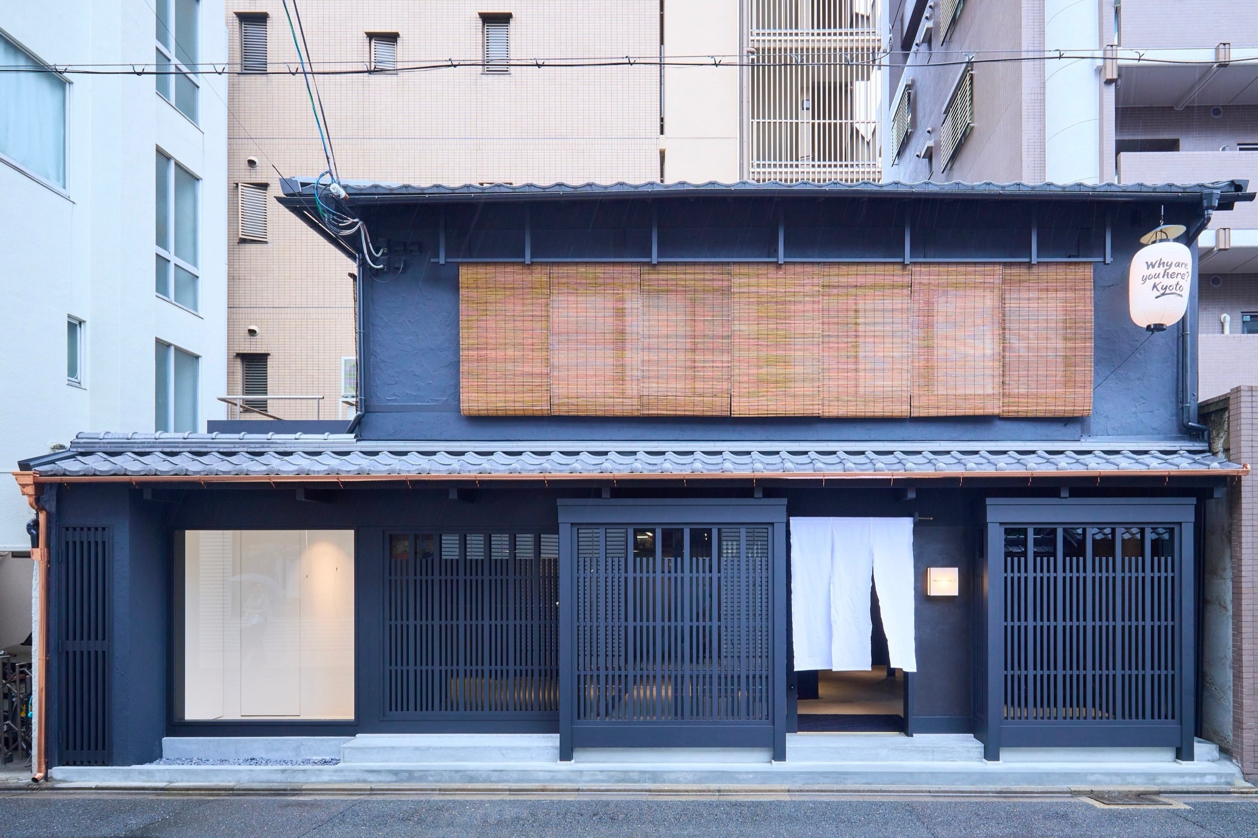 8 August · Tiled eaves and lattice screens kept, the whole front painted deep navy. A paper lantern hangs at the right eave. ⓒSanki Shoji / PR TIMES