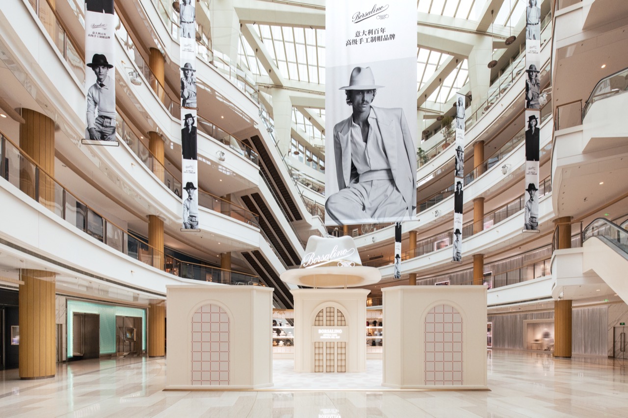 Every upper floor faces one way · The atrium. Vertical banners on each level pull the eye downward. ⓒBorsalino