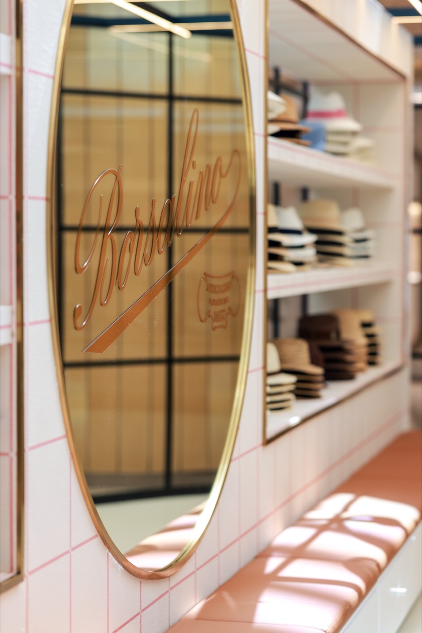 The name cut into the mirror · The brass-rimmed mirror. The trying-on spot and the logo were tied into one place. ⓒBorsalino