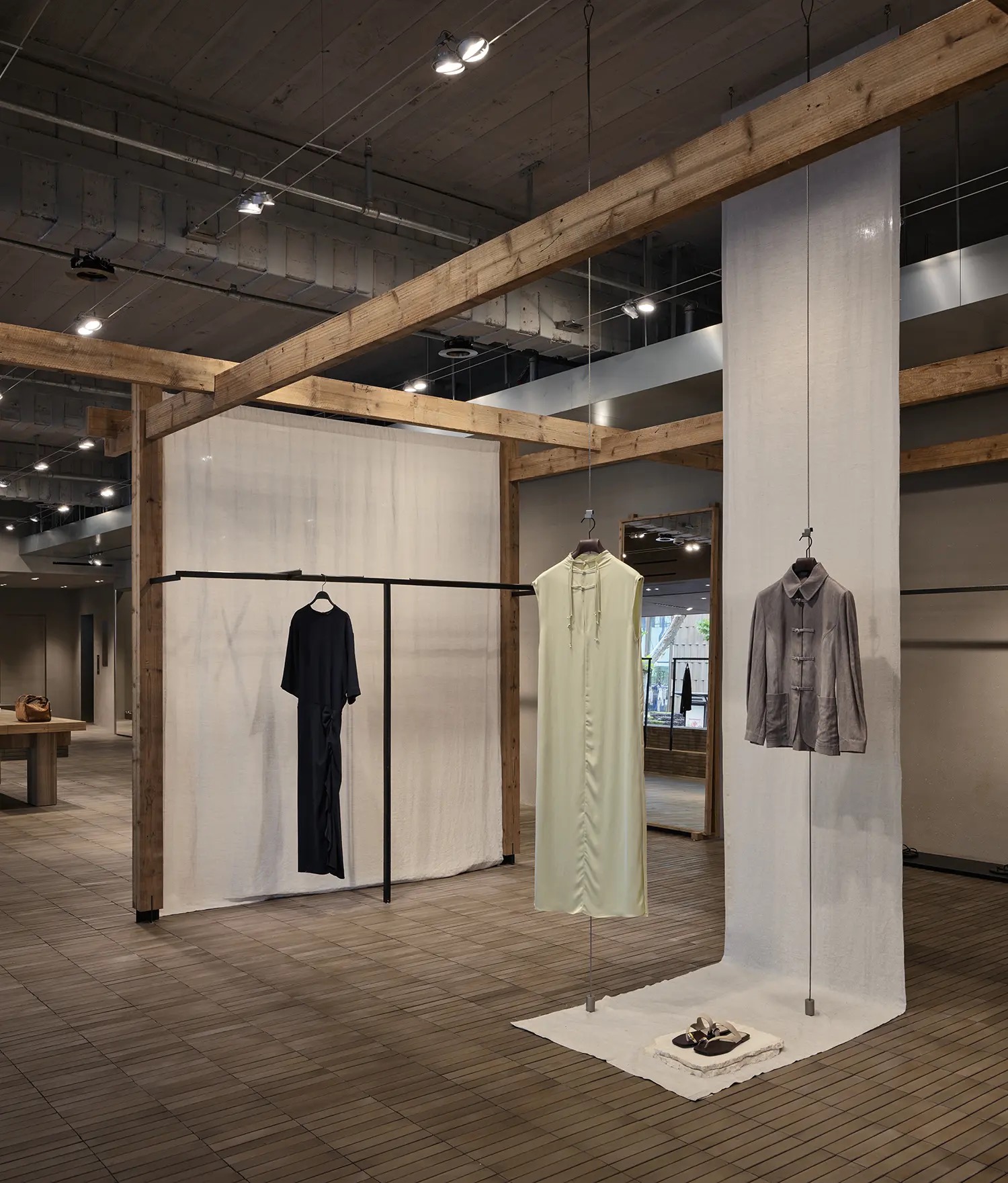 나무 기둥과 리넨 막 · 나무 기둥 사이에 리넨을 늘어뜨리고 옷을 한 벌씩 매달았다. ⓒAIM Architecture·Seth Powers