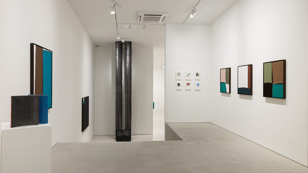 展示風景 · コンクリートの床に階段の開口がある展示室。ⓒWhitestone Gallery