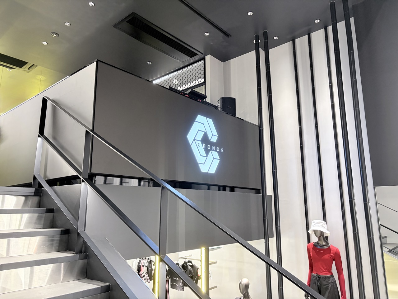 Stairs to the upper floor · A glowing logo hangs on the landing wall. ⓒ大阪ミナミジャーナル