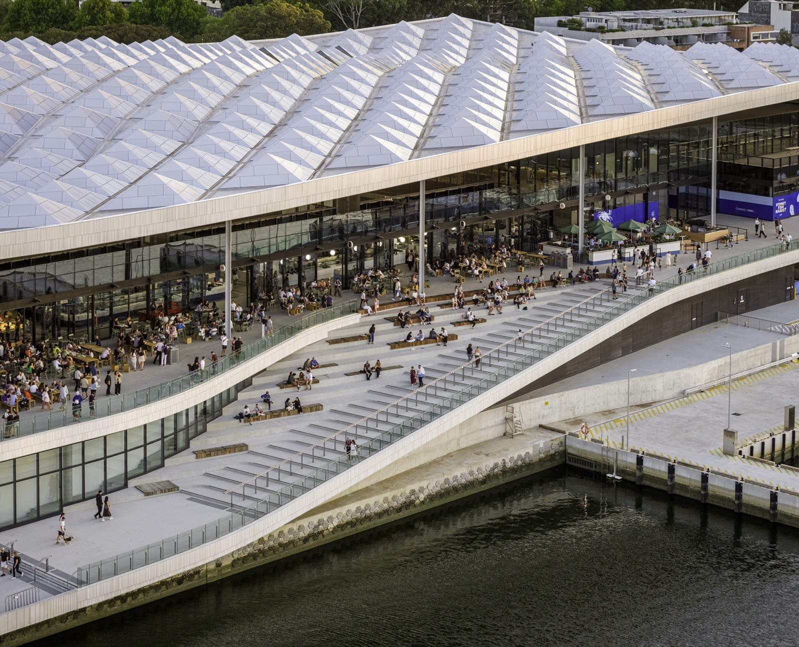 230メートルの波が一枚 · ブラックワトルベイの水辺に据わった新しいSydney Fish Market。屋根ひとつで卸売・小売・飲食・公共空間をすべて覆う。2026年1月19日開場。ⓒRasmus Hjortshøj / 3XN