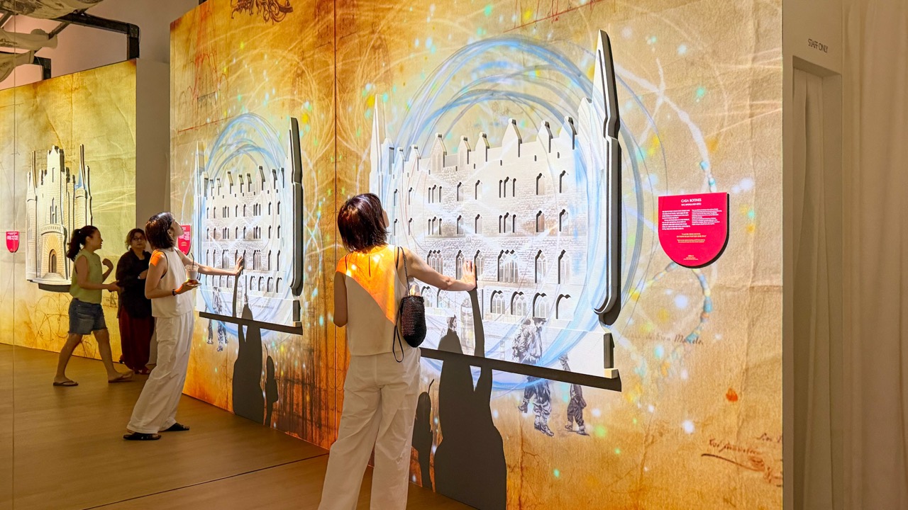 触る展示 · 壁に付けた建物のレリーフに手を当てる来場者。ⓒBRIQUE Magazine