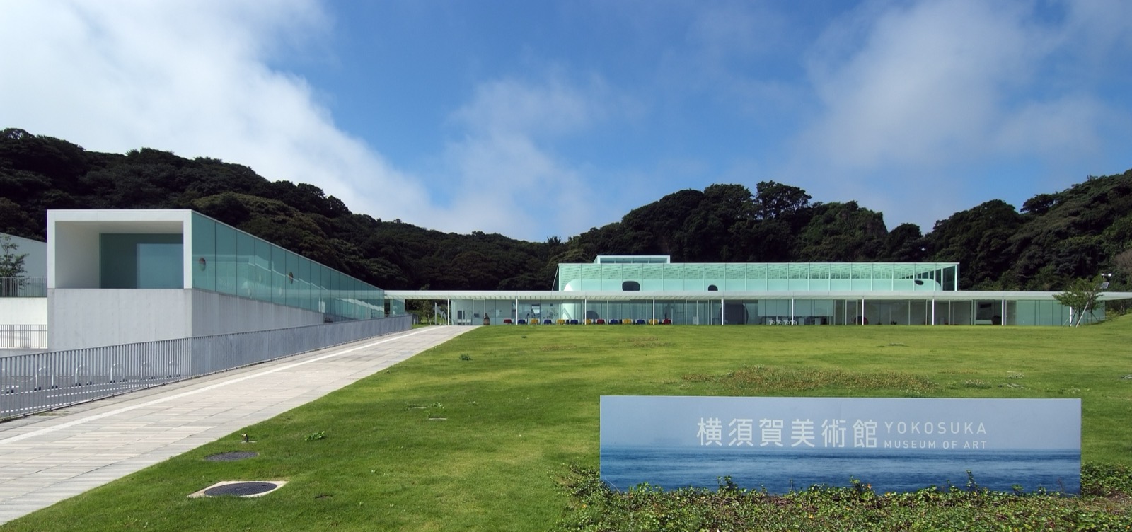 산 앞에 낮게 누운 유리 상자 · 숲을 등지고 잔디밭 끝에 선 요코스카 미술관. 지상으로 드러난 부분은 2개 층뿐이다. ⓒWiiii (CC BY-SA 3.0)
