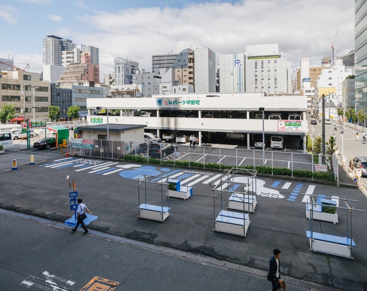 駐車場を背にした空き地 · 平日の昼、ベンチだけが置かれたGAS STAND。奥の白い建物は立体駐車場。ⓒYosuke Ohtake