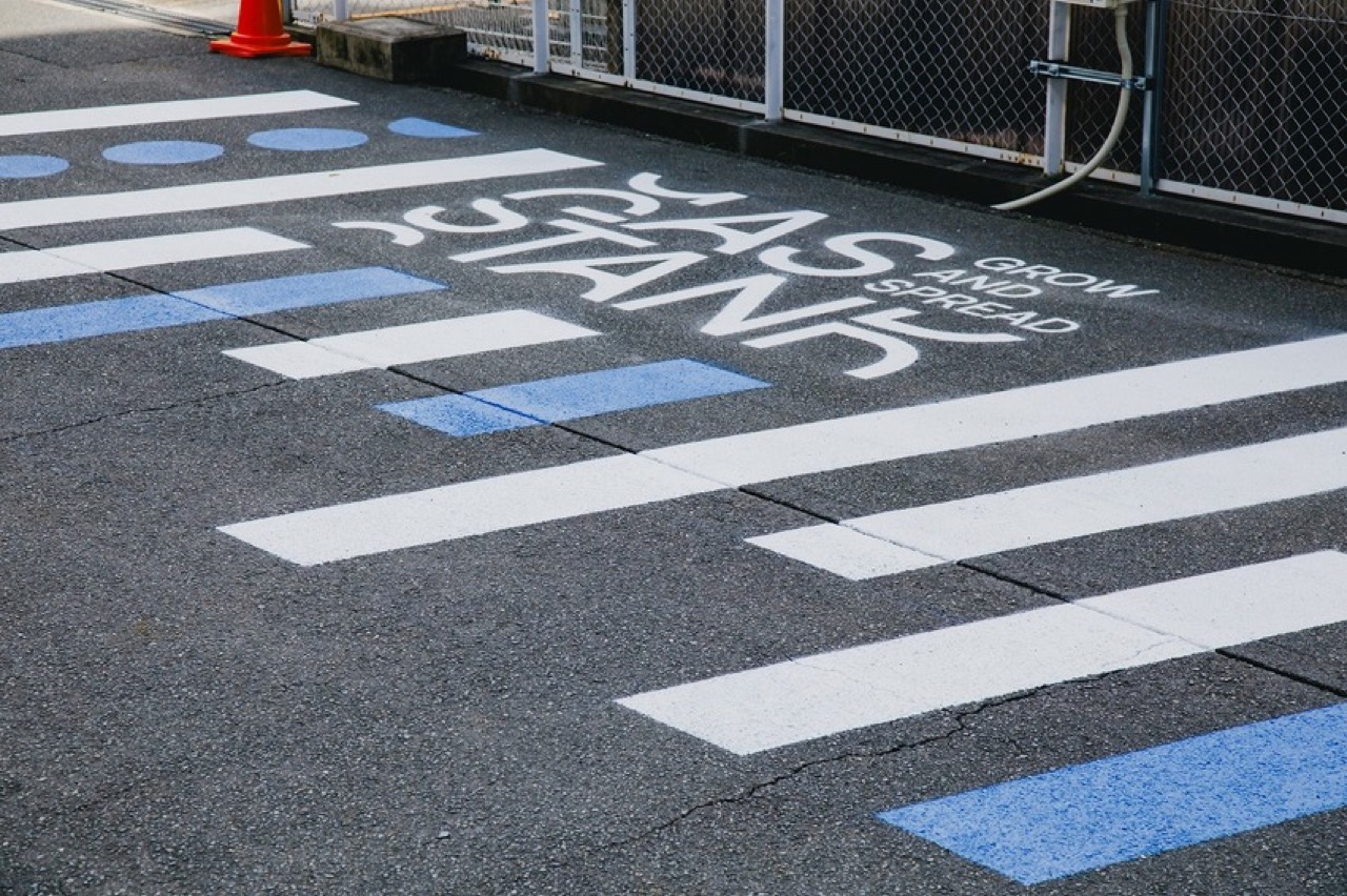 横断歩道に似た縞 · 道路標示をまねた白と青の帯の間に名前を書いた。ⓒYosuke Ohtake