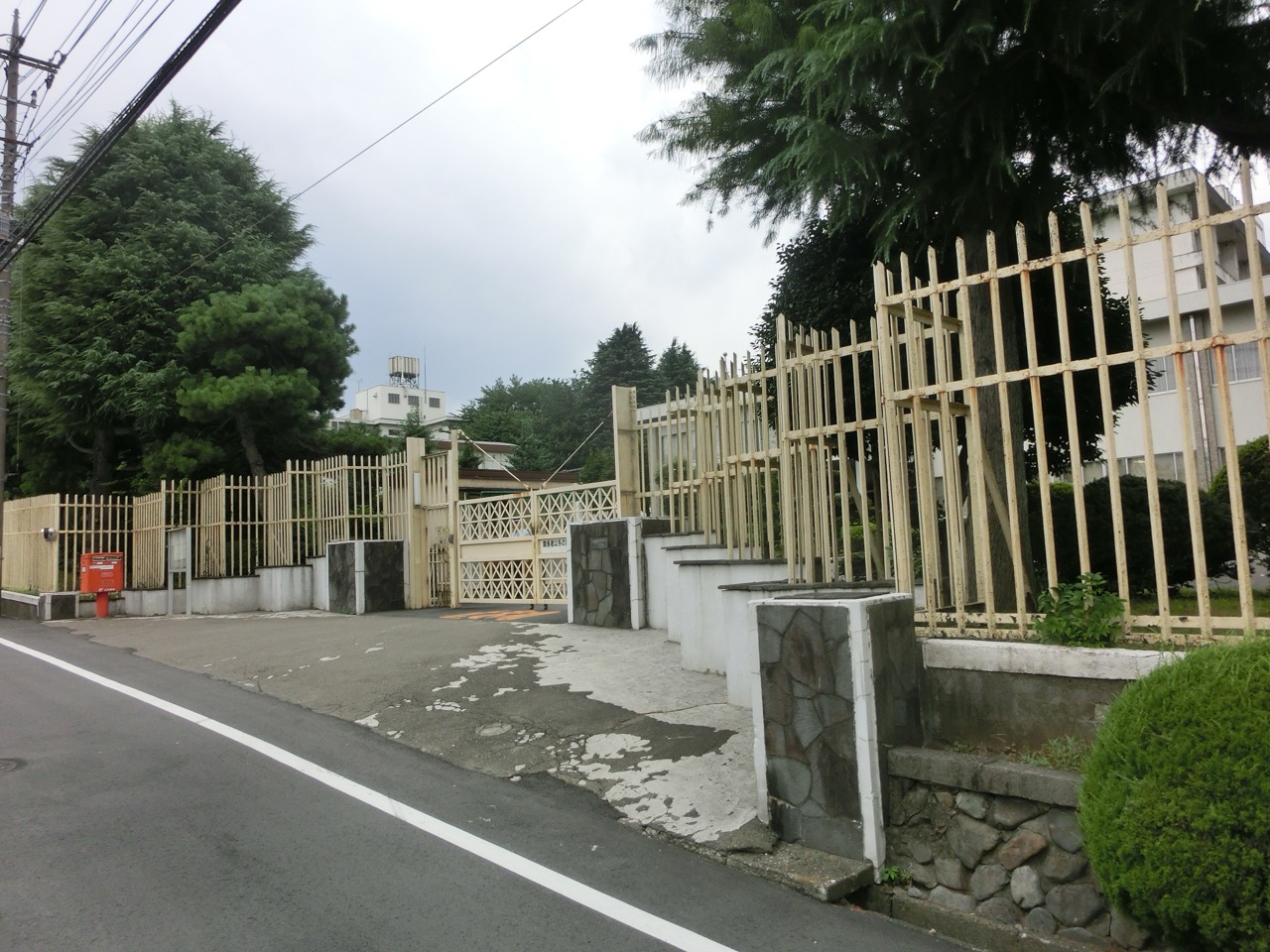 閉鎖前の刑務所の入口 · 住宅地の道沿いに鉄柵と鉄の門が続いていた。内側の建物は外からほとんど見えなかった。ⓒWaka77 · Wikimedia Commons(パブリックドメイン)