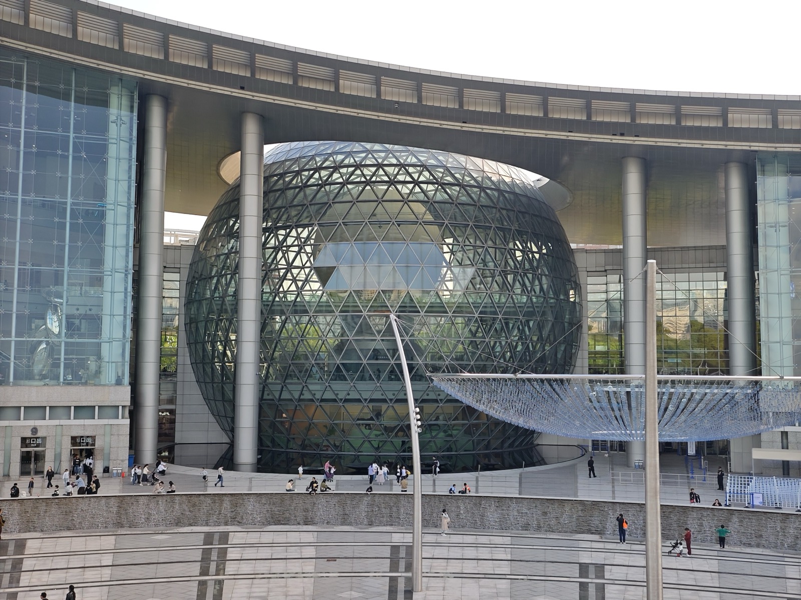 The Shanghai Science and Technology Museum, reopened · April 2026. The glass sphere still sits under the curved roof exactly as it did in 2001. ⓒDvTor8303 · Wikimedia Commons (CC0)