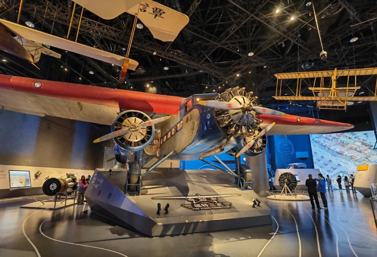 The Ford Trimotor in the aviation zone · A real 1930s airliner on the floor, biplane models overhead. ⓒXinhua (新华网)