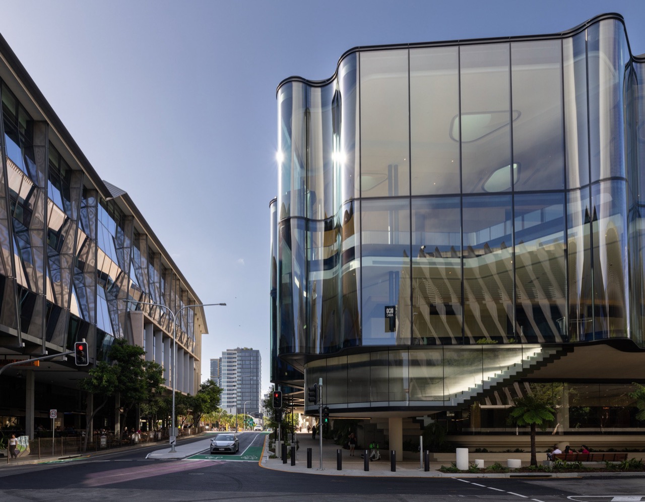 The first floor reaching over the street · The six-metre cantilever across both street frontages forms a canopy. An outdoor stair climbs to the first-floor foyer. ⓒSnøhetta