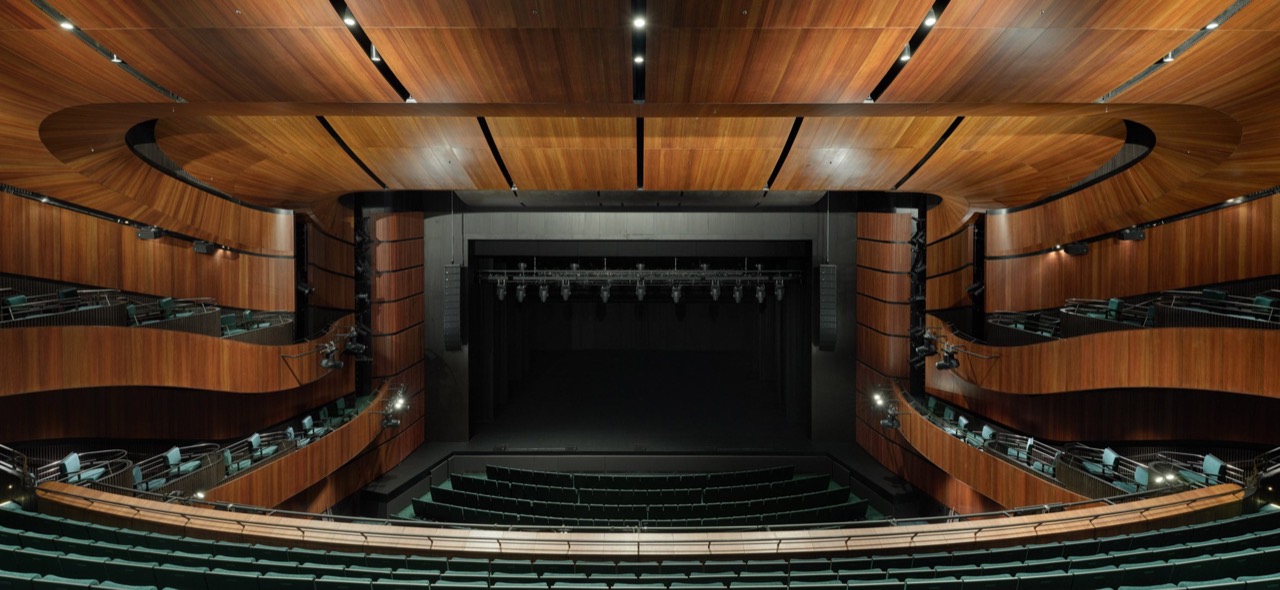 The 1,500-seat auditorium · Timber-banded balconies run along both side walls down to the stage. ⓒChristopher Frederick Jones · via Dezeen