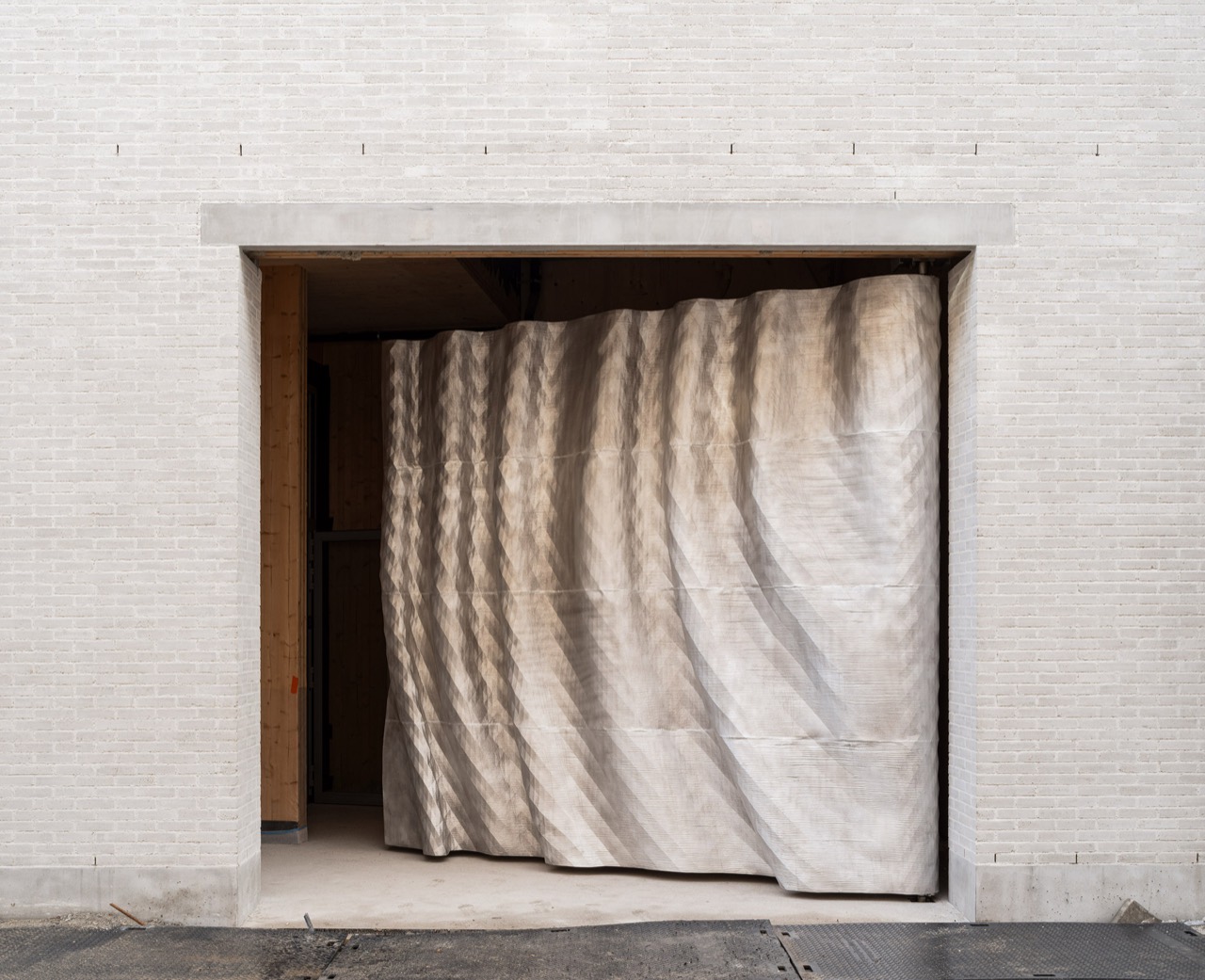 3Dプリントのアルミ扉 · 布を垂らしたように波打つ表面。Unfoldの作品。©Michiel De Cleene・Dezeen掲載